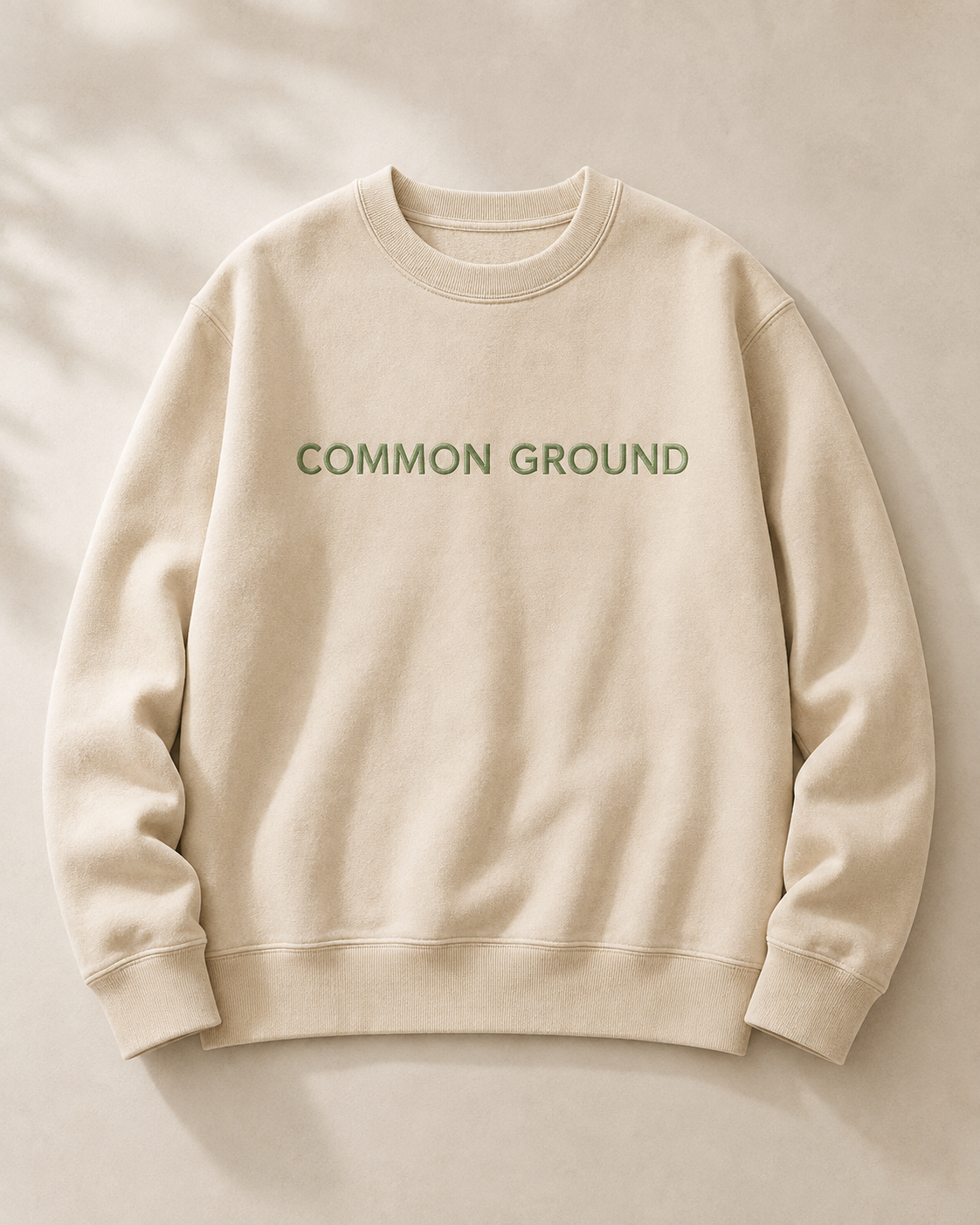 COMMON GROUND と刺繍したベージュのスウェット
