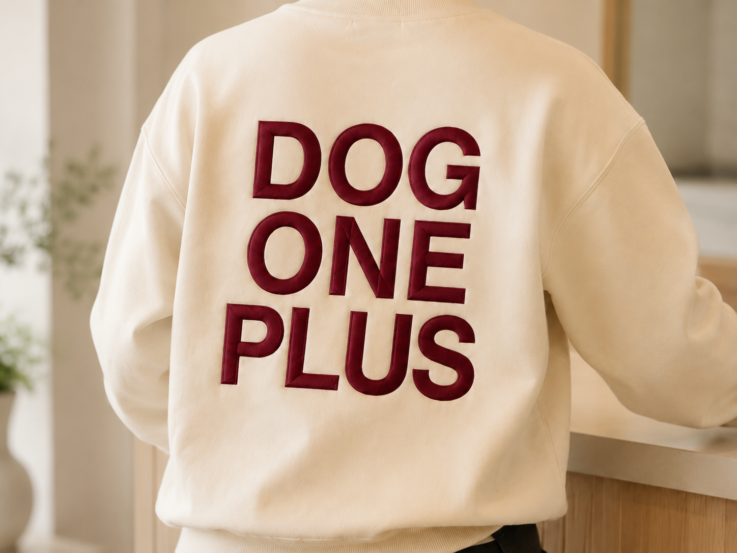 生成りのスウェットの背中に、ワインレッドの糸で厚く盛り上げた DOG ONE PLUS のロゴ